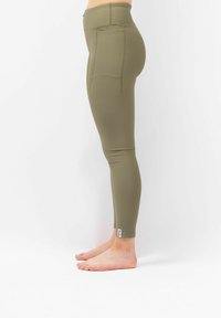Olijfgroene leggings met een ribbelstructuur, hoge taille en twee zijzakken. Past strak om het been tot aan de enkel.