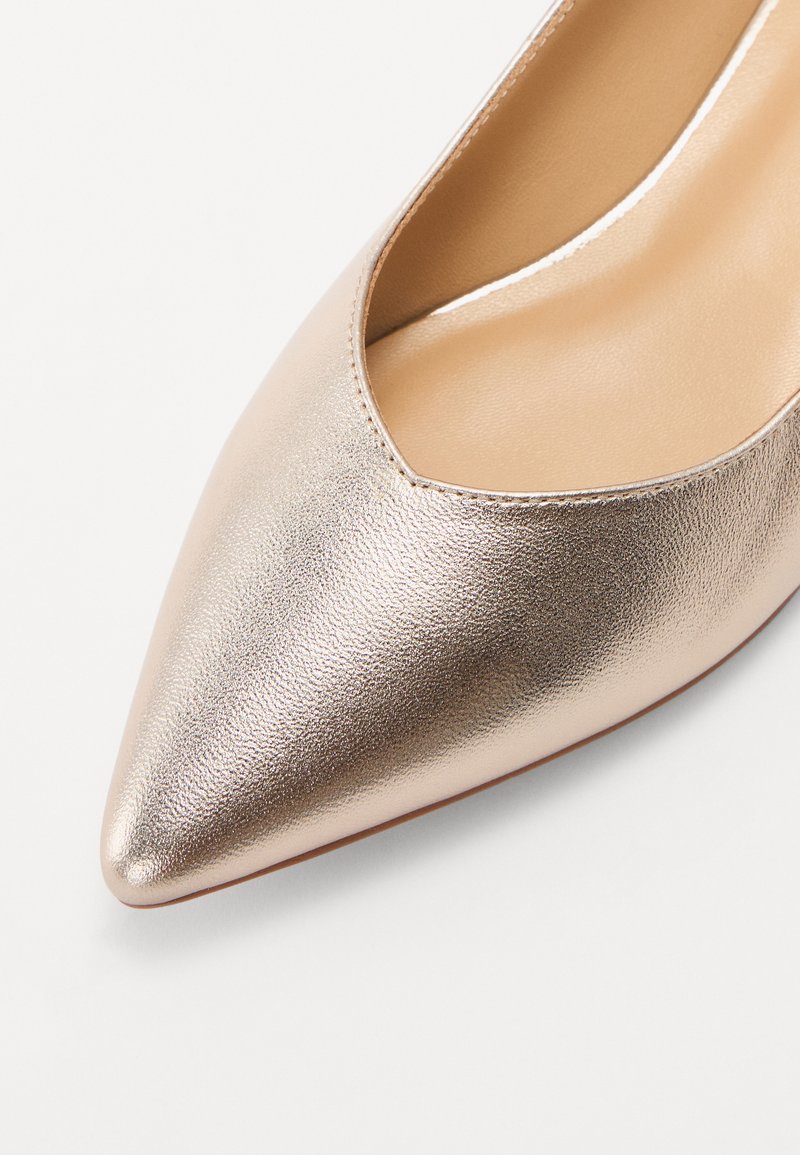 Zapato de tacón alto con punta afilada en cuero metálico rosa dorado, con una textura suave y un diseño recortado a lo largo del borde superior.
