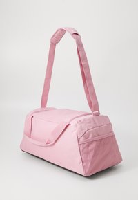 Sac de sport rose avec un dessus zippé, une bandoulière réglable et une poche latérale en mesh. Fabriqué en tissu durable avec une forme rectangulaire.