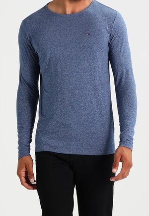 Pitkähihainen tummansininen t-paita, joka on valmistettu jerseymateriaalista. Ominaisuuksiin kuuluu pyöreä pääntie ja logo-patch rinnassa. Sujuva rakenne ja istuva muotoilu.