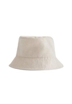 Beige bomuldsbøllehat med synlige syninger langs kanten, der viser en enkel og blød stoftekstur.