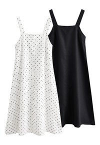 Two sleeveless dresses: one in white with black polka dots, one in solid black. Both feature straight cuts and thin straps.