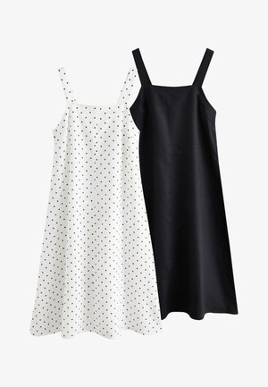 Dvě šaty bez rukávů: jedny bílé s černými puntíky, druhé jednobarevné černé. Oba modely mají rovné střihy a tenké ramínka.