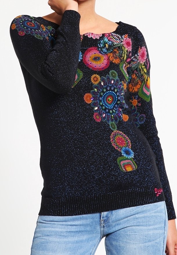 Sort, glitrende sweater med farverige blomster mønstre. Har en bred halsudskæring og ribbet kanten. Bæres med lysblå denim jeans.