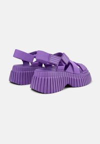 Sandali platform viola con suola in gomma scanalata, cinturini in tessuto regolabili e design chunky. Presentano una finitura testurizzata.