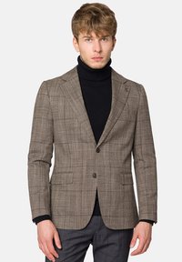 Brązowa marynarka w kratę o dopasowanym kroju, z pojedynczym zapięciem na guzik, klapami notch oraz przednimi kieszeniami, nałożona na czarny golf.