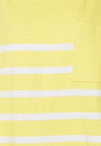 T-shirt amarelo listado com riscas brancas horizontais, apresentando um pequeno bolso na lateral esquerda, feito de um tecido suave.