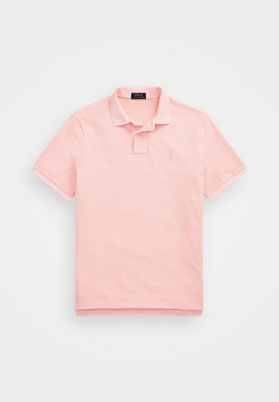 Tricou polo roz deschis, fabricat din bumbac, cu un guler clasic, mâneci scurte și un logo brodat subtil pe piept.