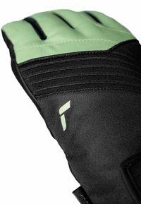 Schwarze Handschuhe mit einem grünen oberen Abschnitt; verfügen über ein texturiertes Gewebe, erhöhte Nähte und ein Logo im Handgelenkbereich. Designed für Griff und Flexibilität.