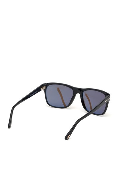 Gafas de sol negras con montura rectangular y lentes azul oscuro. Presenta un material plástico brillante y elegante, con detalles en dorado en las patillas.