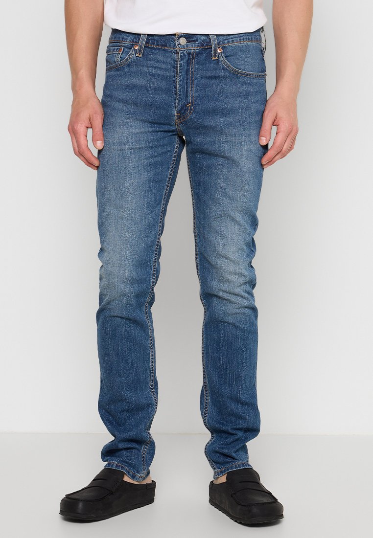 Niebieskie dżinsy o slim fit, z efektem wyblaknięcia, pięcioma kieszeniami, kontrastowym szwem oraz tradycyjnym zapięciem na guzik.