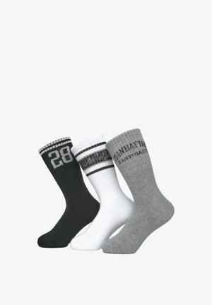 Trzy pary skarpetek: czarne z numerem „28”, białe w czarne paski i szare z tekstem. Każda skarpetka ma prążkowane mankiety i gładką teksturę.