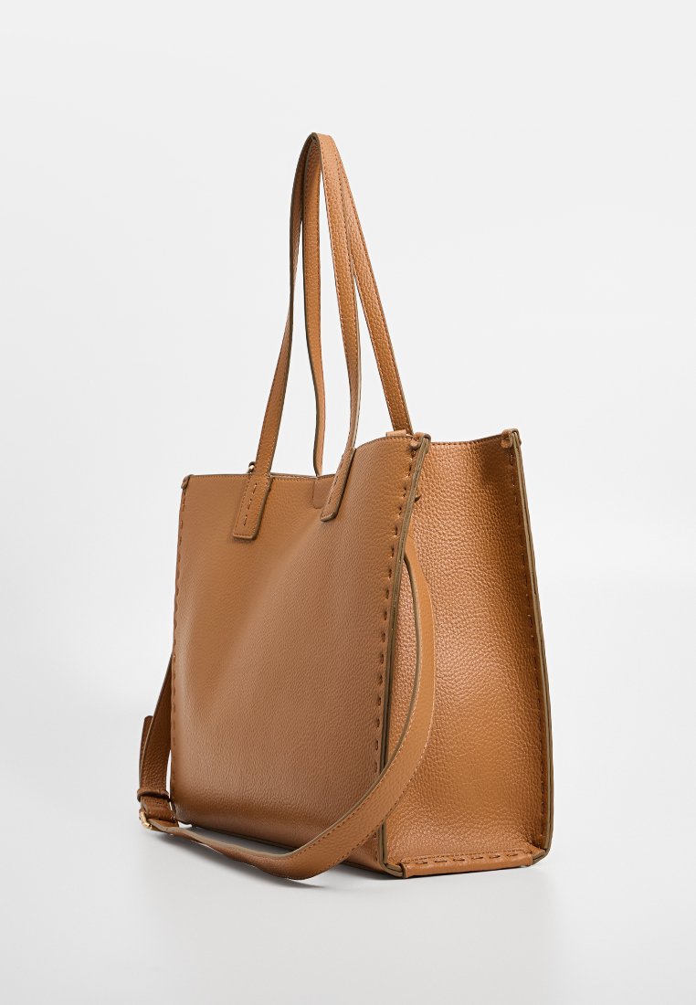 Sac fourre-tout en cuir marron avec une finition texturée, deux poignées et un subtil effet de surpiqûre le long des bords. Design à ouverture supérieure.