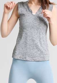Top gris sin mangas con diseño de escote en V, hecho de una tela jaspeada, que presenta un corte relajado y una sutil textura.