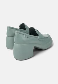 Lichtgroene platform loafers met een gladde leren afwerking, brede ronde neus en een chunky blokhak, met subtiele stikdetails.