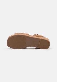 Sandale compensée marron avec semelle en caoutchouc, grip texturé sur le talon et la partie avant du pied, et deux sangles à boucles sur le dessus.