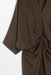 Dark brown fabric dress with wide sleeves and gathered, ruched detailing at the waist creating draped folds.