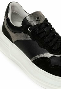 Black and silver sneaker with a textured surface. Features a padded collar, black laces, and a thick white sole with a ridged pattern.