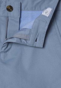 Pantaloni in cotone azzurro chiaro con zip anteriore, chiusura con bottone e dettagli interni in vita. Texture liscia con una trama fine.