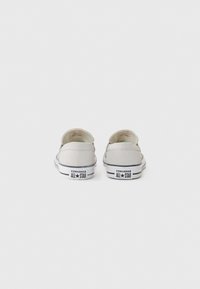 Grå penn-sneakers med lav topp-design, hvite gummisåler og svarte stripe-detaljer. Har "Converse All Star"-logoen på hælen.