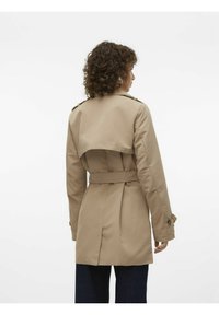 Beige trenchcoat med belagd midja, axelremmar på axlarna och en draperad ryggdesign. Tillverkad av ett mjukt, lätt tyg.
