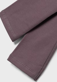 Lilla bomullslegginger med en glatt tekstur, med pent sydder mansjetter. Stoffet virker mykt og fleksibelt, ideelt for komfort.