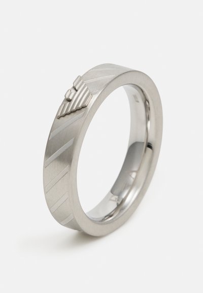 Metal ring featuring a brushed silver finish, with a ridged design and a raised triangular accent. Smooth inner surface.