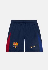 Marina fotbollsshorts med sidopaneler i röd och blå, en broderad Barcelona-logotyp på vänster ben och en gul Nike-logotyp.