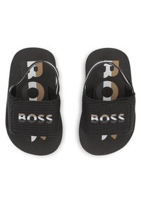 Μαύρα σανδάλια slides από συνθετικό υλικό. Διαθέτουν υφασμένη λουρά με το λογότυπο "BOSS" και πασπαρτού πέλμα σε μαύρο και χρυσό χρώμα.