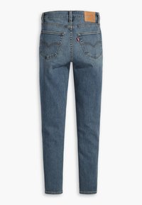 Pantalones vaqueros de denim azul con corte recto, que cuentan con dos bolsillos traseros, un parche de cuero en la cintura y detalles de costura visibles.