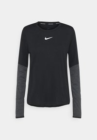 Svart långärmad träningströja med grå ärmar. Har en rund halsringning och en vit Nike-logotyp på bröstet. Slät textur, avslappnad design.