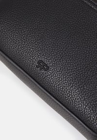 Clutch nera in pelle con superficie texturizzata, dotata di logo impresso. La forma è rettangolare con bordi arrotondati e rifinitura liscia.