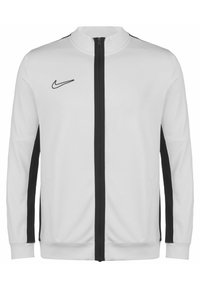 Weiße Nike-Jacke mit hohem Kragen, schwarzen Seitenstreifen und einem Reißverschluss auf der Vorderseite. Weicher Stoff mit glatter Textur.