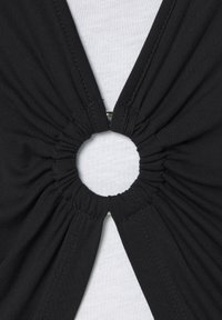 Black fabric featuring gathered texture around a circular opening, secured with metal hardware, creating a unique cut-out design.
