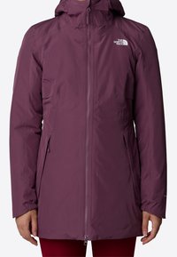 Veste imperméable violette avec fermeture éclair, capuche ajustable et plusieurs poches ; texture lisse avec poignets élastiques et détail de logo.