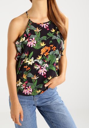 Top halter floreale caratterizzato da colori vivaci su uno sfondo nero, con un design arricciato e spalline sottili, abbinato a jeans azzurri chiari.
