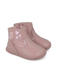 Botas de tobillo de cuero rosa con cremalleras laterales, bordes ondulados y apliques de pájaro y corazón. Suela texturizada para agarre y comodidad.