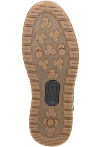 Gumowa podeszwa buta z heksagonalnym wzorem, w jasnobrązowym kolorze, z teksturowanym uchwytem. Charakteryzuje się centralnym czarnym akcentem z logo.