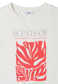 T-shirt blanc à col rond, motif abstrait de feuilles rouges et texte « SCENTS OF SALT AND FRESH PINE — FORGET ABOUT TIME » sur le devant.