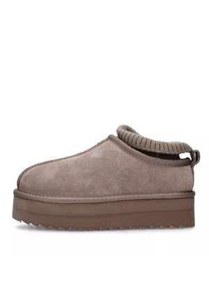 Scarpa slip-on in suede beige con collo lavorato a maglia. Presenta una suola piattaforma spessa, marrone, con bordi seghettati e dettagli cuciti.