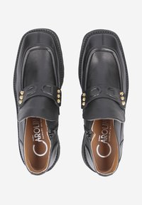 Schwarze Leder Slipper mit abgerundetem Zehenbereich, dekorativen goldfarbenen Nieten auf einem Riemen und einer gepolsterten Innensohle.