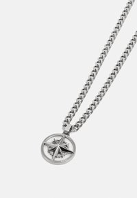 Silver chain necklace featuring a round compass pendant with a five-pointed star design, polished finish, and subtle branding on the pendant.
