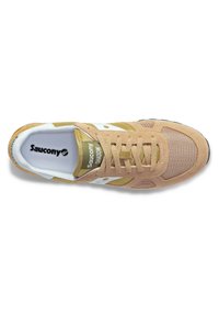 Beige és zöld Saucony sportcipők, hálós és velúr anyagból, kerek orral, fehér részletekkel és lapos fűzőkkel. Texturált felületi részletek.