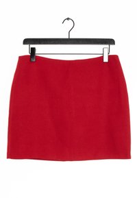 Jupe mini A-line rouge suspendue à un cintre noir. Le tissu semble lisse avec un léger éclat, présentant un ourlet net et sans motifs visibles.