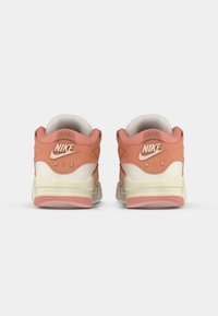 Nike Air tenisice s gornjim dijelom u bijeloj i svijetlopink boji, mekanom baršunastom teksturom, velikim logotipom i udobnom krem i ružičastom potpeticom.