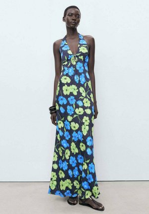 Halter-neck maxi dress in dark fabric with bright blue and green floral patterns; features a fitted bodice and flowing skirt.