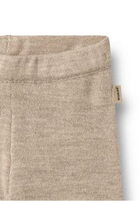 Beiger Strickstoff mit einer weichen Textur. Verfügt über einen breiten Bund und ein kleines Markenetikett an der Seite.