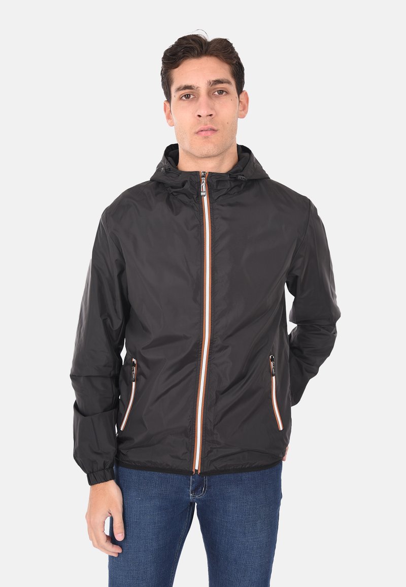 Giacca leggera nera con cappuccio, caratterizzata da dettagli arancioni sulla zip e due tasche frontali. Texture liscia e design aderente.