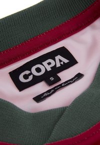 Baumwolletikett mit "COPA" in Weiß, Größe 'S' und "Made in Europe." Mit grünem und kastanienbraunem geripptem Kragen und einem rosa Innenfutter.