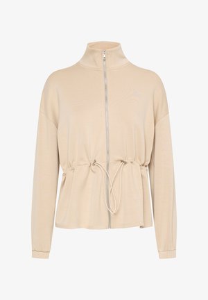 Chaqueta beige con cremallera, cuello alto, cintura fruncida y mangas largas. Presenta un cordón en la cintura y una textura de tela suave.